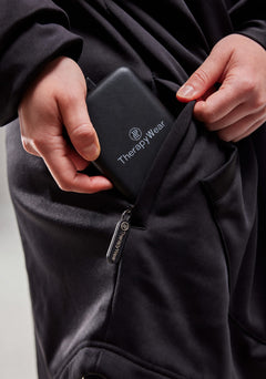 TherapyWear power bank going into the zipped pocket of the hoodie
