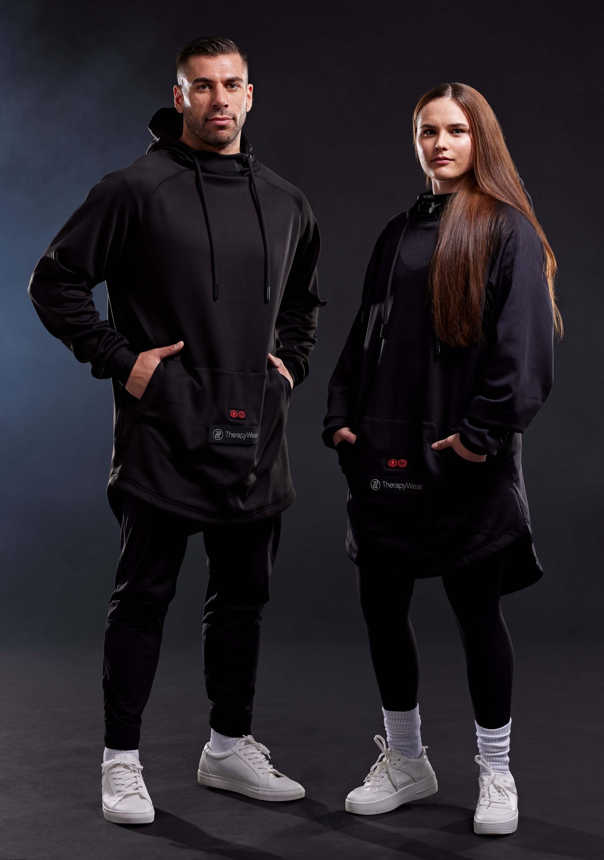 Man and woman wearing the TherapyWear Relief Hoodie in a studio